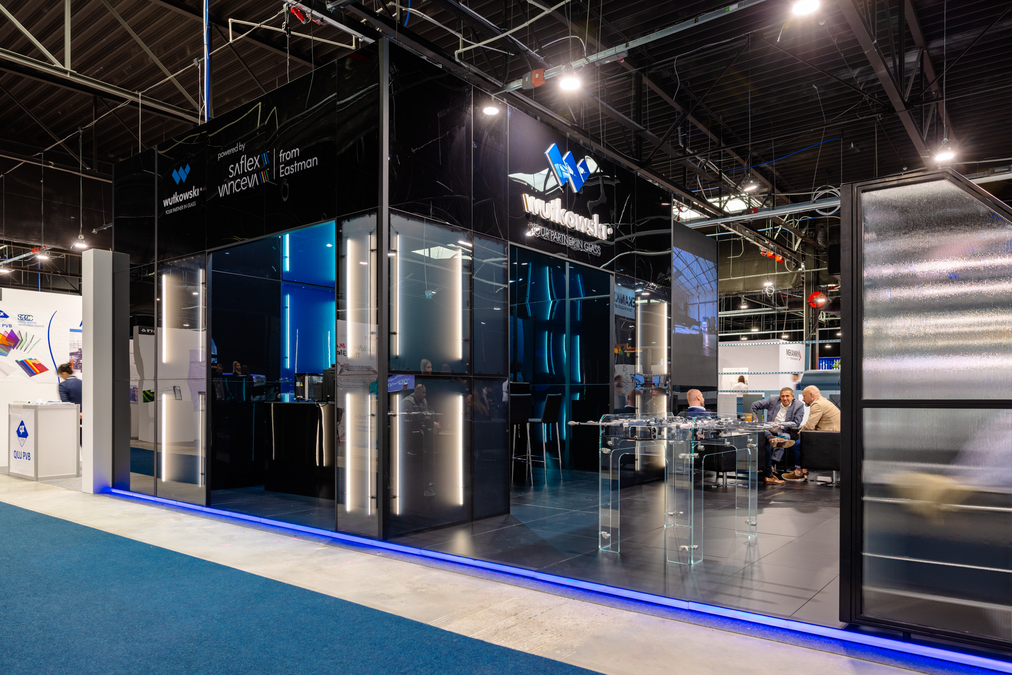 Wutkowski trade show stand in a black and navy blue colour scheme, featuring linear lighting